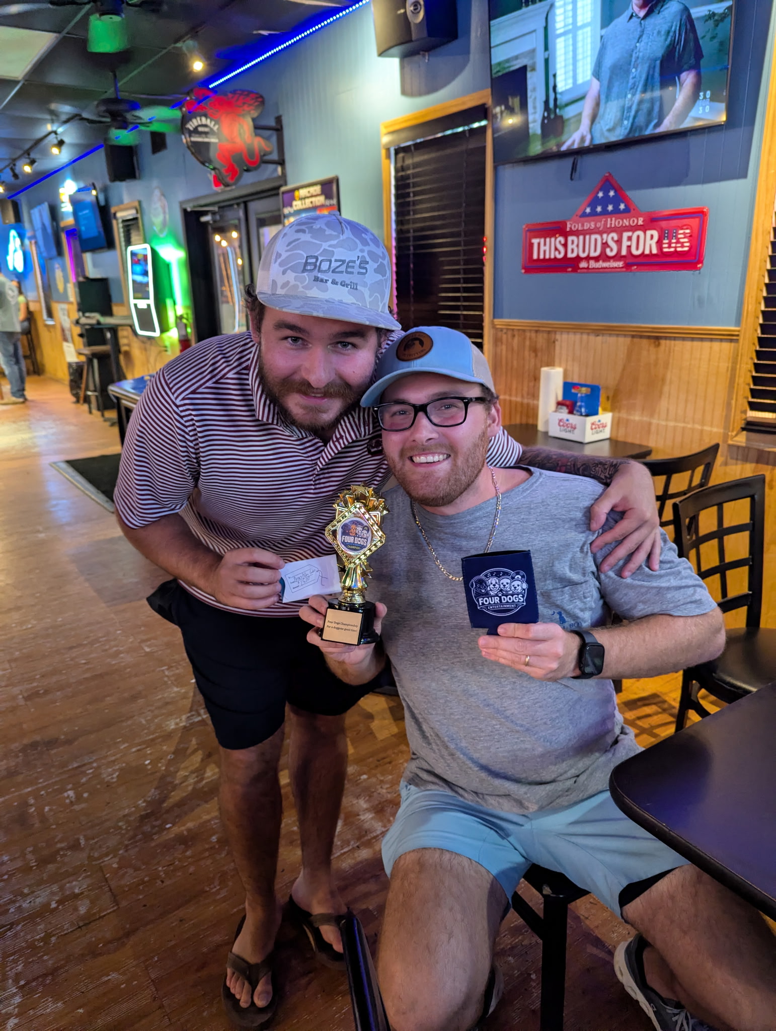 Two winners posing with the Four Dogs Entertainment championship trophy after Survey Showdown at Boze’s Restaurant & Bar